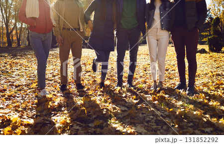 Picture of middle and lower parts of the body of several people in autumn park, dressed in warm colorful clothes. Picture of middle and lower parts of the body of several people in autumn park, dressed in warm colorful clothes. 131852292