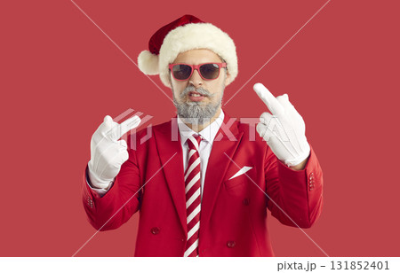 Cool cheeky man in Santa hat showing middle finger demonstrating that go fuck you. 131852401