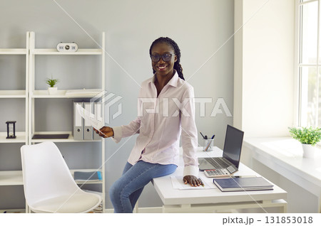 Portrait of happy smiling young African American business woman at work in office 131853018