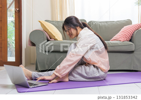 Healthy lifestyle health woman teen at home engaged in physical exercise yoga sport workout, following digital instruction on laptop display. Healthy lifestyle health woman teen at home engaged in physical exercise yoga sport workout, following digital instruction on laptop display. 131853342
