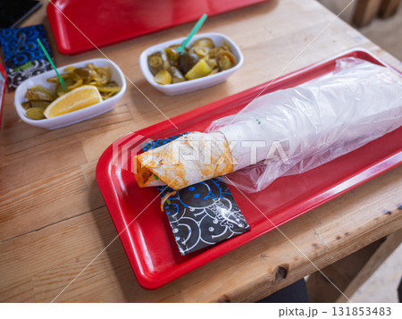 【トルコ】イスタンブール郊外のレストランのテーブルに並ぶチキンシュワルマとピクルス 131853483