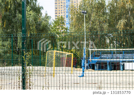 Beach sports court behind green fence goal and volleyball posts horizontal photo Beach sports court behind green fence goal and volleyball posts horizontal photo 131853770