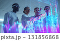 Diverse group of four professionals analyzing data on digital screen in modern office. They are engaged and focused, showcasing teamwork and collaboration in tech driven environment 131856868
