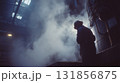worker in heavy safety gear stands in smoky industrial environment, surrounded by steam and machinery, reflecting intensity of industrial labor 131856875