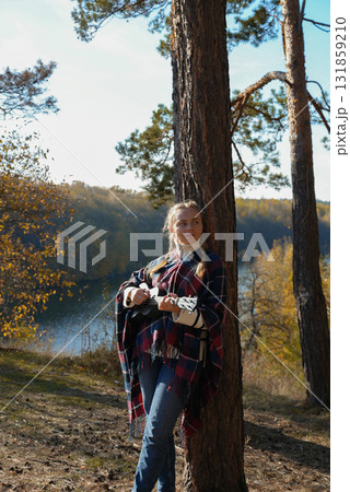 Blonde woman playing guitar ukulele outdoors in autumn forest. Concept of sound therapy, mental health and wellness rituals. Calmness tranquility audio-sensory practices. Aura farming Blonde woman playing guitar ukulele outdoors in autumn forest. Concept of sound therapy, mental health and wellness rituals. Calmness tranquility audio-sensory practices. Aura farming 131859210
