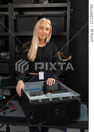 Female IT technician in a data center upgrading server hardware and performing maintenance 131860799