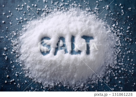 Top view of coarse white salt fully covering a background surface with the word SALT written clearly on the granular surface Top view of coarse white salt fully covering a background surface with the word SALT written clearly on the granular surface 131861228