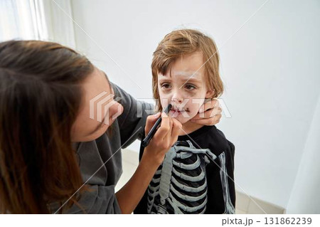 A Child Enjoying Getting Halloween Makeup Done for Their Fun Skeleton Costume Look A Child Enjoying Getting Halloween Makeup Done for Their Fun Skeleton Costume Look 131862239