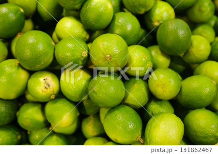 Fresh limes piled together in a vibrant display at a local market during the morning hours of a sunny day Fresh limes piled together in a vibrant display at a local market during the morning hours of a sunny day 131862467