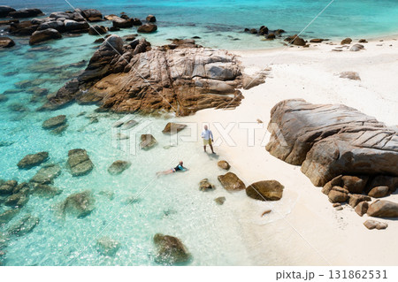 Tourists relax on a tropical beach with white sand and large rocks on the island of Lang Tengah, Terengganu, Malaysia 131862531