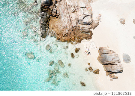 A couple in love is relaxing on a beach with white sand and large rocks on the island of Lang Tengah, Terengganu, Malaysia A couple in love is relaxing on a beach with white sand and large rocks on the island of Lang Tengah, Terengganu, Malaysia 131862532