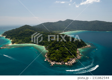 Aerial view of the Perhentian Islands in Malaysia. Serene view of the coast with lush green hills and clear blue waters on a sunny day in a tropical location Aerial view of the Perhentian Islands in Malaysia. Serene view of the coast with lush green hills and clear blue waters on a sunny day in a tropical location 131862544