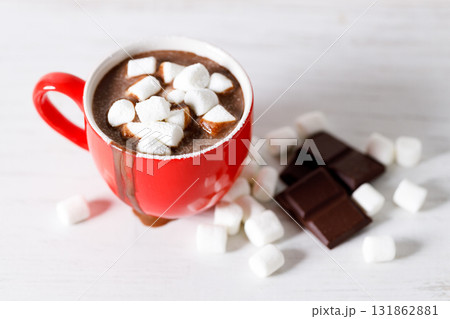 Hot chocolate in red cup on white wooden table background. 131862881