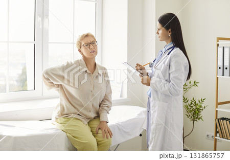 Senior Patient Consulting Doctor About Back Pain At Hospital 131865757