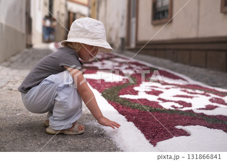 Girl looking at a traditional colorful carpet in Portugal during a Catholic festival 131866841