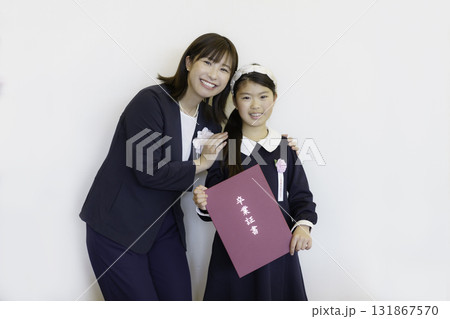 卒業式　卒業証書を持つ小学生の女の子と先生　撮影協力：学校法人電波学園 東京電子専門学校 131867570