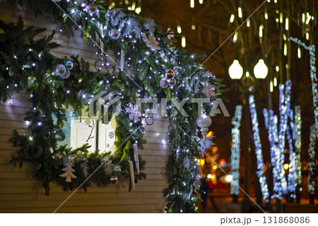 Christmas Window Decor with Lights and Garland on Festive Street at Night 131868086
