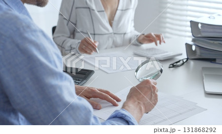 Groupe of accounting professionals analyzing financial documents, checking spreadsheet details with calculator and magnifying glass. Audit and taxes concept Groupe of accounting professionals analyzing financial documents, checking spreadsheet details with calculator and magnifying glass. Audit and taxes concept 131868292
