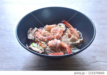 fried vegetarian Chinese yellow rice noodles with shrimp and chicken couple carrot topping slice black mushroom on bowl fried vegetarian Chinese yellow rice noodles with shrimp and chicken couple carrot topping slice black mushroom on bowl 131870660