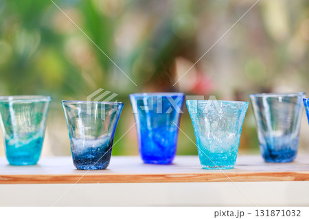 琉球グラスの並ぶテーブルと自然光の背景 131871032