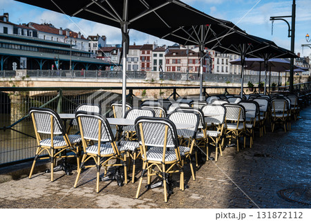 川沿いのレストランの店先に並ぶテーブルと歴史的な建物の街並み　フレンチバスク地方のバイヨンヌの街にて 131872112