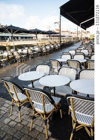 川沿いのレストランの店先に並ぶテーブルと歴史的な建物の街並み　フレンチバスク地方のバイヨンヌの街にて 131872116