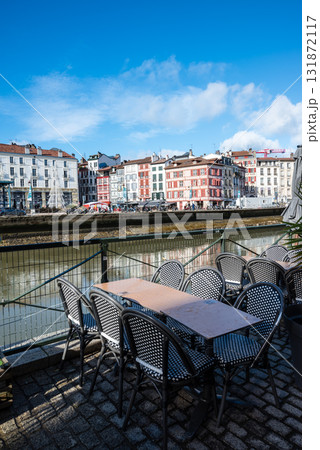 川沿いのレストランの店先に並ぶテーブルと歴史的な建物の街並み　フレンチバスク地方のバイヨンヌの街にて 131872117