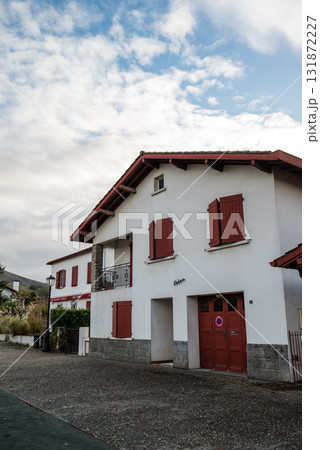 フレンチバスク地方の唐辛子で有名なエスプレット村の唐辛子の飾りが付いた赤と白の建物 131872227