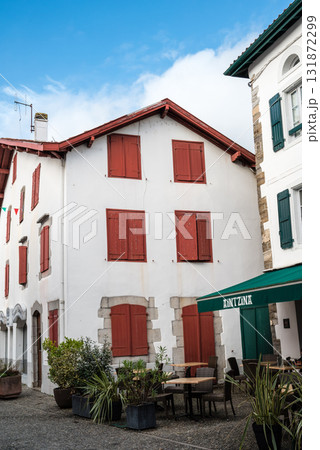 フレンチバスク地方の唐辛子で有名なエスプレット村の唐辛子の飾りが付いた赤と白の建物 131872299