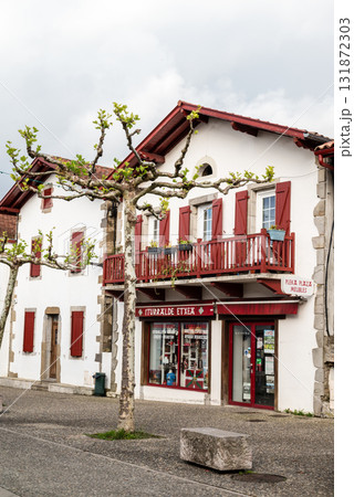 フレンチバスク地方の唐辛子で有名なエスプレット村の唐辛子の飾りが付いた赤と白の建物 131872303