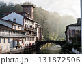 朝もやの中の川沿いに立つ歴史的な建物と木々　フレンチバスク地方のサン・ジャン・ピエ・ド・ポールにて 131872506