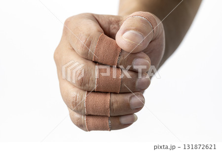 Fist with finger bandages is shown, conveying sense of resilience and healing. bandages are wrapped around fingers, indicating recovery or protection Fist with finger bandages is shown, conveying sense of resilience and healing. bandages are wrapped around fingers, indicating recovery or protection 131872621