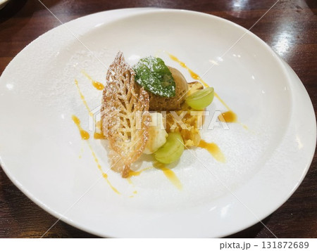 柑橘系のフルーツ入りのチーズケーキとキャラメルのアイスクリーム リーフ型クッキー添え 131872689