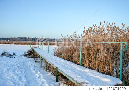 An old rustic wooden pier on Ivanovsky Bay in winter. Ulyanovsk. Russia An old rustic wooden pier on Ivanovsky Bay in winter. Ulyanovsk. Russia 131873069