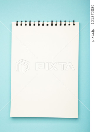White spiral notebook mockup on blue background. Vertical photo White spiral notebook mockup on blue background. Vertical photo 131873089