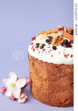 Traditional easter cakes with colorful sprinkles and spring flowers on purple background. Vertical photo Traditional easter cakes with colorful sprinkles and spring flowers on purple background. Vertical photo 131873118