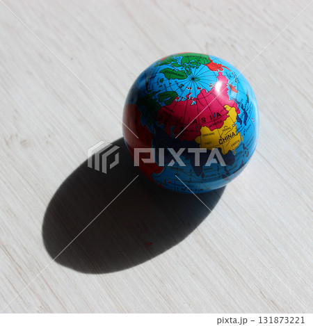 A deep shadow cast by a globe on the illuminated side, showing the countries of the Asian continent A deep shadow cast by a globe on the illuminated side, showing the countries of the Asian continent 131873221