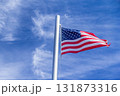 American Flag Waving In The Wind Against A Blue Sky . 131873316