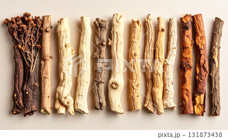 A neatly arranged flat lay of dried adaptogenic roots and herbs such as ashwagandha and rhodiola, displayed in small wooden bowls on a neutral background, symbolizing natural wellness and balance 131873438