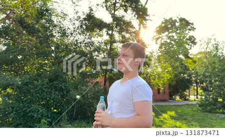 BABY BOY DRINKING WATER AT SUNSET PARK, DRINKING HEALTH REGIMEN, Child feeling refreshed, Hydration in motion, Water in sunny weather, Afternoon park session, Keeping cool, Summer safety tips, Teen 131873471