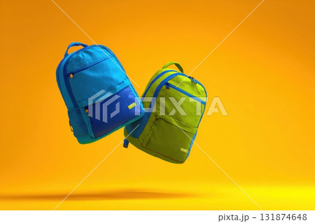Two vibrant neon green and blue backpacks floating in the air isolated on yellow background. Colorful school bags are suspending mid-air. Dynamic movement composition. product presentation, playtime Two vibrant neon green and blue backpacks floating in the air isolated on yellow background. Colorful school bags are suspending mid-air. Dynamic movement composition. product presentation, playtime 131874648