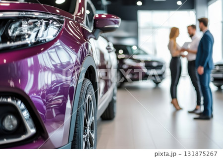 Car dealer discussing contract with client customer in a showroom. Salesman showing selling cars to a couple at the dealership. Sales manager helping to choose a new car. Congratulations for buying 131875267