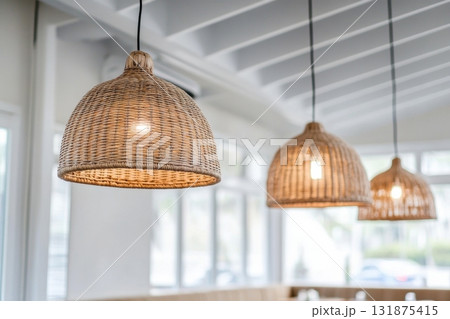 Straw lampshade. Modern pendant lights with light bulb. Contemporary house interior. Hanging ceiling light in a current shared space. Decorative geometric lamp. Suspended straws chandelier loft style. Straw lampshade. Modern pendant lights with light bulb. Contemporary house interior. Hanging ceiling light in a current shared space. Decorative geometric lamp. Suspended straws chandelier loft style. 131875415