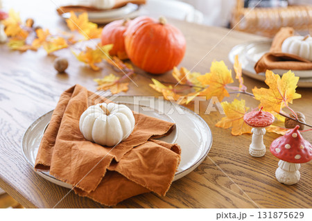Autumn, fall, Halloween or Thanksgiving festive day table setting with yellow leaves and pumpkins Autumn, fall, Halloween or Thanksgiving festive day table setting with yellow leaves and pumpkins 131875629