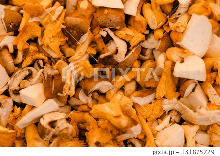 Fresh mushrooms including chanterelles and porcini arranged in a pile, symbolizing forest harvest Fresh mushrooms including chanterelles and porcini arranged in a pile, symbolizing forest harvest 131875729