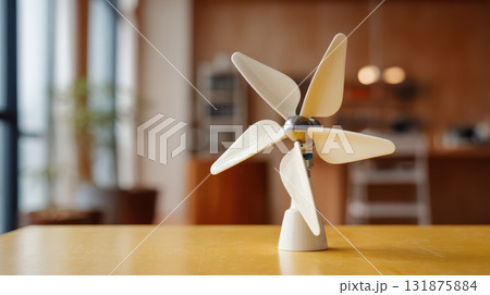 Small wind turbine model clean energy technology on yellow table in modern interior Small wind turbine model clean energy technology on yellow table in modern interior 131875884