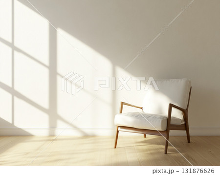 An empty, sunlit room with a modern wooden armchair, featuring strong geometric shadows. 131876626