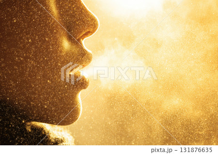 Warm golden sunlight illuminates close up of person exhaling visible breath in cold air, creating dreamy, atmospheric, and tranquil winter scene with glowing particles 131876635