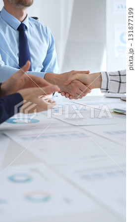 Business partnership success concept with handshake in modern office, financial charts, graphs and laptop on desk representing teamwork, agreement and corporate growth Business partnership success concept with handshake in modern office, financial charts, graphs and laptop on desk representing teamwork, agreement and corporate growth 131877199