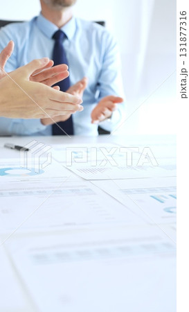 Diverse business people clapping hands in meeting celebrating success with financial charts, performance reports, teamwork, company growth, and management achievement 131877316